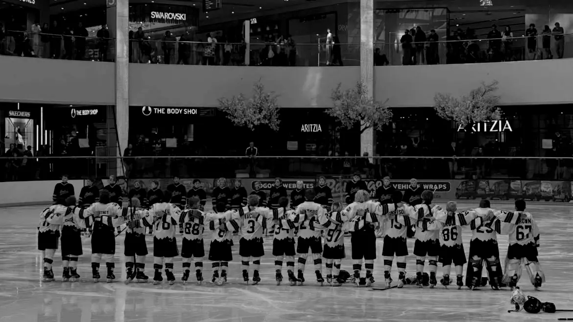 Apex Hockey Academy players lined up arm in arm on the ice at West Edmonton Mall